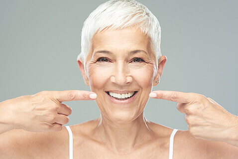 Mature woman pointing at her smile
