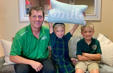 Reilly kids holding Smile pillow